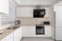 eine weiße Küche mit Spüle und Kühlschrank in der Unterkunft Sahara - Designed Duplex with a private pool in Eilat