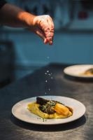 una mano buscando un plato de comida en una mesa en Northern Lights Ranch, en Levi