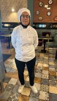a woman in a chef outfit standing in a restaurant at Rachos in Oujda