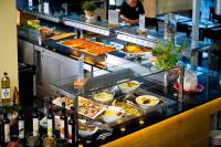 uma linha de buffet com alimentos e garrafas de vinho em Ferienhauspark Asgard in Damp em Damp