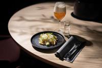 默恩达尔Best Western Plus Åby Hotel的桌子上摆着一盘食物和一杯啤酒