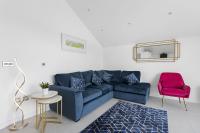 ein Wohnzimmer mit einem blauen Sofa und einem roten Stuhl in der Unterkunft Teign View, Grand Banks in Teignmouth