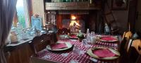 a table with a red table cloth and a fireplace at Auberge du Ruxelier J&D in Cheniménil