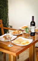 a wooden table with plates of food and a bottle of wine at Hotel Odonata Real in Cartagena de Indias