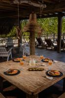 una mesa de madera con platos de comida y copas de vino en Casa del Mar by Al Alma, en San Onofre