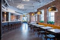 a row of tables and chairs in a room with brick walls at Hotel Hive in Washington