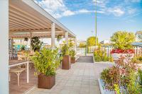 a patio with tables and chairs and potted plants at Hotel Sirena - B&B in Cesenatico