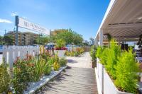 a walkway in front of a building with plants at Hotel Sirena - B&B in Cesenatico