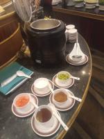 a table with plates of food and a large pot at First Pacific Cirrus in Pattaya Central