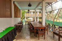 Un comedor con mesas y sillas y ventanas. en Sea Trails Bentota, en Bentota