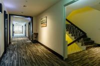 a hallway with a staircase with a yellow wall at 53 Hotel in Taichung