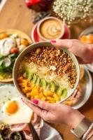 una persona che tiene una ciotola di cibo su un tavolo di Uno Express a Bangkok