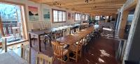 a row of wooden tables and chairs in a restaurant at Freeride Hostel in Les Crosets