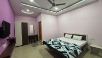 Un dormitorio con una cama y un televisor de pantalla plana. en Sun Shine Residency, en Dibrugarh