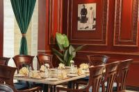 a dining room with a long table and chairs at Faletti's Grand Hotel Gujranwala in Gujrānwāla