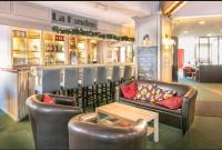 LʼHuezにあるAppartement ALPE D HUEZ dans Résidence Les Bergersの革張りの椅子、ソファ、テーブルが備わるバー