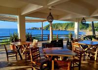 Posada Ziga Playa في مازونتي: مطعم مع طاولات وكراسي وإطلالة على المحيط