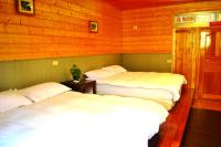 three beds in a room with wooden walls at Zhong Ming Ju Taoyi Fang in Fanlu