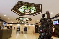 a statue in a lobby with a stained glass ceiling at Atami Hotel in Taipei