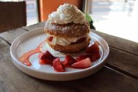 una pasta en un plato con fresas en una mesa en Cottage Suites, en Middletown