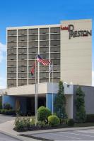 a hotel with two american flags in front of it at Hotel Preston Nashville Airport in Nashville