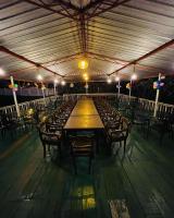 een lange houten tafel en stoelen in een gebouw bij Araliya Villa in Balapitiya