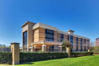 un edificio con una valla delante de un patio en Heritage Inn Suites Houston Sugar Land, Trademark by Wyndham, en Sugar Land