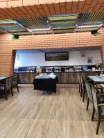 a dining room with tables and chairs and a counter at Eastin Dè Royalè in Hyderabad