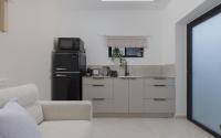 eine kleine Küche mit einem Kühlschrank und einem Sofa in der Unterkunft אורה דירות אירוח -נץ 9- דירות נופש איכותיות לנופש שקט ואקסלוסיבי in Eilat