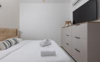 ein Schlafzimmer mit einem Bett und einem Flachbildfernseher in der Unterkunft אורה דירות אירוח -נץ 9- דירות נופש איכותיות לנופש שקט ואקסלוסיבי in Eilat
