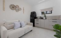 ein Wohnzimmer mit Couch und Küche in der Unterkunft אורה דירות אירוח -נץ 9- דירות נופש איכותיות לנופש שקט ואקסלוסיבי in Eilat