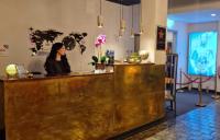 una mujer sentada en un bar en una habitación en Amical Hotel Hagen - Am Hauptbahnhof, en Hagen