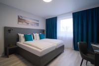 a bedroom with a large bed with blue curtains at Hotel Kiel by MELIO in Kiel