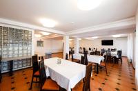 a dining room with white tables and chairs at Pensiunea Petra- Clisura Dunarii in Divici