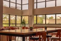 Una gran sala con mesas, sillas y ventanas. en Rede Andrade SLZ, en São Luís