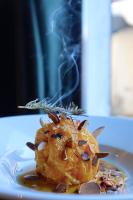 a plate of food on a table with smoke at Au Vieux Moulin in Megève
