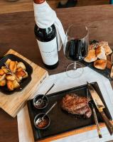 图蓬加托火山House by Casa Septem的一张桌子,上面放着一瓶葡萄酒和一盘食物