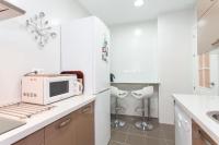a white kitchen with a microwave and a sink at Casa Singular , parking gratis in Jerez de la Frontera