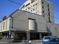 un edificio con un gran edificio con coches aparcados delante en HOTEL LiVEMAX Toyooka, en Toyooka