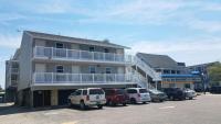 ein Gebäude mit auf einem Parkplatz geparkten Autos in der Unterkunft Atlantic Breeze Motel &amp; Apartments in Ocean City