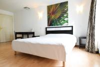 a bedroom with a white bed and a painting on the wall at Residhotel Mulhouse Centre in Mulhouse