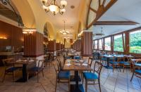 パラッドにあるErzsébet Park Hotelのテーブルと椅子と窓のあるダイニングルーム