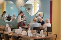 een groep mensen die aan tafels in een restaurant zitten bij DOMITYS - Les Aviateurs in Muret