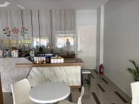 Un restaurante con un mostrador, una mesa y sillas. en Florens Inn, en Jetis