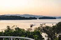 ein Boot auf dem Wasser mit Bergen im Hintergrund in der Unterkunft Le La Lake Resort and Spa in Kaeng Kachan