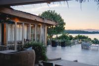 ein Haus mit einer Terrasse mit Blick auf das Wasser in der Unterkunft Le La Lake Resort and Spa in Kaeng Kachan
