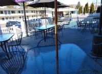 an empty patio with tables and chairs with an umbrella at Bend Inn & Suites in Bend