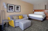 a hotel room with a bed and a couch at Courtyard Aberdeen at Ripken Stadium in Aberdeen