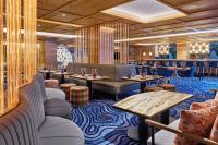 um restaurante com mesas, cadeiras e um bar em W Aspen em Aspen