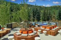 um pátio com mesas, piscina e árvores em W Aspen em Aspen